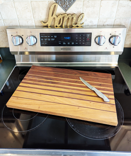 Varied thickness walnut sapwood and heartwood strips interposed with continuous grain to form a pleasingly symmetrical cutting board.